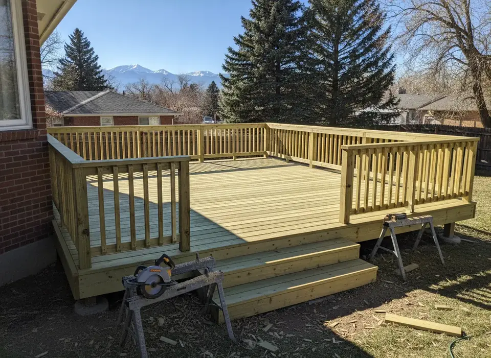 New wood deck with stairs, sawhorses and tools nearby